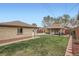 Manicured backyard features a covered patio, grass area, and a brick wall at 4840 Depew St, Denver, CO 80212