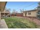 Well-maintained backyard with green grass, brick planter and wooden fence at 4840 Depew St, Denver, CO 80212