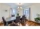 Elegant dining room featuring a wooden table, chandelier, and hardwood floors illuminated by natural light at 4840 Depew St, Denver, CO 80212