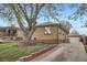 Brick home with a detached garage, featuring a paved driveway and neat landscaping on a sunny day at 4840 Depew St, Denver, CO 80212