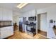 Kitchen featuring white cabinets, stainless steel appliances, and access to the dining area at 4840 Depew St, Denver, CO 80212
