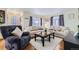 Bright living room with hardwood floors, neutral sofas, and natural light from large windows at 4840 Depew St, Denver, CO 80212