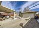 Covered patio with seating, a grill, and a detached garage with basketball hoop in the background at 4840 Depew St, Denver, CO 80212