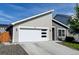 Beautiful home featuring a modern garage door, gray siding, and a well maintained lawn at 719 S Hoover Ave, Fort Lupton, CO 80621