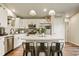 Modern kitchen with white cabinets, center island with seating, stainless appliances, and wood floors at 719 S Hoover Ave, Fort Lupton, CO 80621