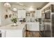 Modern kitchen with white cabinets, center island with bar stools, stainless appliances, and decor at 719 S Hoover Ave, Fort Lupton, CO 80621