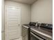 A laundry room with a white door and front-loading washer and dryer sets at 719 S Hoover Ave, Fort Lupton, CO 80621