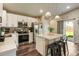 Open concept living with an island, pendant lights, patio door, large television, and a comfortable couch at 719 S Hoover Ave, Fort Lupton, CO 80621