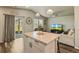 Open concept living with island, pendant lights, ceiling fan, large television, and comfortable furniture at 719 S Hoover Ave, Fort Lupton, CO 80621
