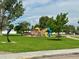 Community playground with colorful play structures, mature trees, and benches for relaxation at 719 S Hoover Ave, Fort Lupton, CO 80621