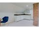 An attic space converted to a living space that includes a sink, workspace, and bright lighting with exposed brick at 1731 S Ogden St, Denver, CO 80210