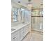 Elegant bathroom featuring dual sinks, tiled floors, and a glass-enclosed shower at 1731 S Ogden St, Denver, CO 80210