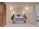 This bedroom features recessed lighting, sconces, modern nightstands and an exposed brick wall for a rustic modern look at 1731 S Ogden St, Denver, CO 80210