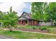 Beautiful two-story brick home with front yard landscaping and mature trees at 1731 S Ogden St, Denver, CO 80210