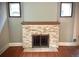 Stone fireplace with wood mantle flanked by two windows and hardwood floors at 1731 S Ogden St, Denver, CO 80210
