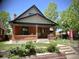 Charming brick home with a covered front porch and well-manicured lawn at 1731 S Ogden St, Denver, CO 80210