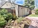 A detached single car garage with a side entry door set in a landscaped yard at 1731 S Ogden St, Denver, CO 80210