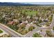 Suburban neighborhood with houses, green spaces, and mountains in the distance at 3229 Swadley St, Wheat Ridge, CO 80033