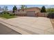 Features a large, extended concrete driveway that leads to the attached garage at 3229 Swadley St, Wheat Ridge, CO 80033