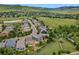 A beautiful aerial view of a neighborhood with green landscapes and a walking path leading to a green mountain at 19067 W 57Th Dr, Golden, CO 80403