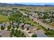 An aerial view of homes along a highway surrounded by greenery, some with solar panels on their roofs at 19067 W 57Th Dr, Golden, CO 80403