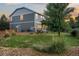 Backyard view showcasing a spacious lawn, wooden fence, and the back of the house with a door at 19067 W 57Th Dr, Golden, CO 80403