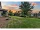 A serene backyard with a well-kept lawn, rock features, garden plants, and a view of the covered patio at 19067 W 57Th Dr, Golden, CO 80403