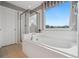 Bright bathroom features a soaking tub, tiled shower, and a large window at 19067 W 57Th Dr, Golden, CO 80403