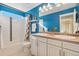 Bright bathroom featuring a double vanity with white cabinets and colorful blue walls at 19067 W 57Th Dr, Golden, CO 80403