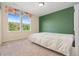Bedroom featuring neutral walls with a vibrant accent wall and bright window at 19067 W 57Th Dr, Golden, CO 80403