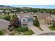 Aerial view of a two-story blue house with a well-manicured front yard and a long driveway at 19067 W 57Th Dr, Golden, CO 80403