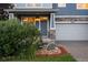 Charming exterior showcasing lush landscaping, stone accents, covered porch, and a two-car garage at 19067 W 57Th Dr, Golden, CO 80403
