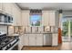 Bright kitchen features stainless steel appliances, white cabinetry, and wood flooring at 19067 W 57Th Dr, Golden, CO 80403