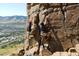 Rock climbers scaling a cliff face with scenic views of the city in the background at 19067 W 57Th Dr, Golden, CO 80403