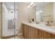 Bathroom featuring double sinks, wood cabinets, a walk-in shower, and mosaic flooring at 1333 Elati St # 3, Denver, CO 80204