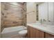 Bathroom featuring a shower-tub combo, wood-look tile walls, and a white sink at 1333 Elati St # 3, Denver, CO 80204