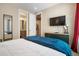 Bedroom showcasing a TV, carpet flooring, stylish decor, and a bathroom with a laundry room at 1333 Elati St # 3, Denver, CO 80204
