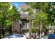 Contemporary gray townhome exterior featuring a private balcony, lush trees, and ample street parking at 1333 Elati St # 3, Denver, CO 80204