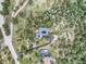 Aerial view of mountain homes surrounded by dense trees, featuring an inviting driveway and picturesque landscape at 7273 Silverhorn Dr, Evergreen, CO 80439