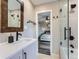 Modern bathroom with a shower, vanity, and an open doorway leading into a bedroom with a ceiling fan at 7273 Silverhorn Dr, Evergreen, CO 80439