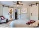 Bright bedroom featuring sliding barn doors, a ceiling fan, and a stylish gray chair with a red and white pillow at 7273 Silverhorn Dr, Evergreen, CO 80439