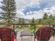 Inviting deck view featuring cozy chairs and a table overlooking a lush landscape with a scenic view at 7273 Silverhorn Dr, Evergreen, CO 80439