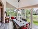 Bright dining room with large windows offering views of the surrounding greenery and a stylish dining table with seating at 7273 Silverhorn Dr, Evergreen, CO 80439