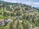 Scenic mountain home surrounded by dense trees, featuring an inviting driveway and tranquil, picturesque landscape at 7273 Silverhorn Dr, Evergreen, CO 80439