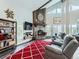Cozy living room with a stone fireplace, vaulted ceilings, large windows with mountain views, and comfortable seating at 7273 Silverhorn Dr, Evergreen, CO 80439