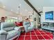 Open-concept living space with kitchen view, featuring vaulted ceilings and two gray recliners at 7273 Silverhorn Dr, Evergreen, CO 80439