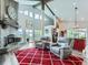 Spacious living room boasting soaring ceilings, clerestory windows, a stone fireplace, and comfortable gray chairs at 7273 Silverhorn Dr, Evergreen, CO 80439