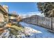 Backyard with wooden fence, covered patio, and snowy ground at 14942 E Evans Ave, Aurora, CO 80014