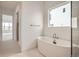 Bathroom with soaking tub, glass shower, and neutral color palette at 3166 Newfound Lake Rd, Berthoud, CO 80513