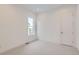 Spacious, carpeted bedroom showcasing a bright window and a classic white door at 3166 Newfound Lake Rd, Berthoud, CO 80513